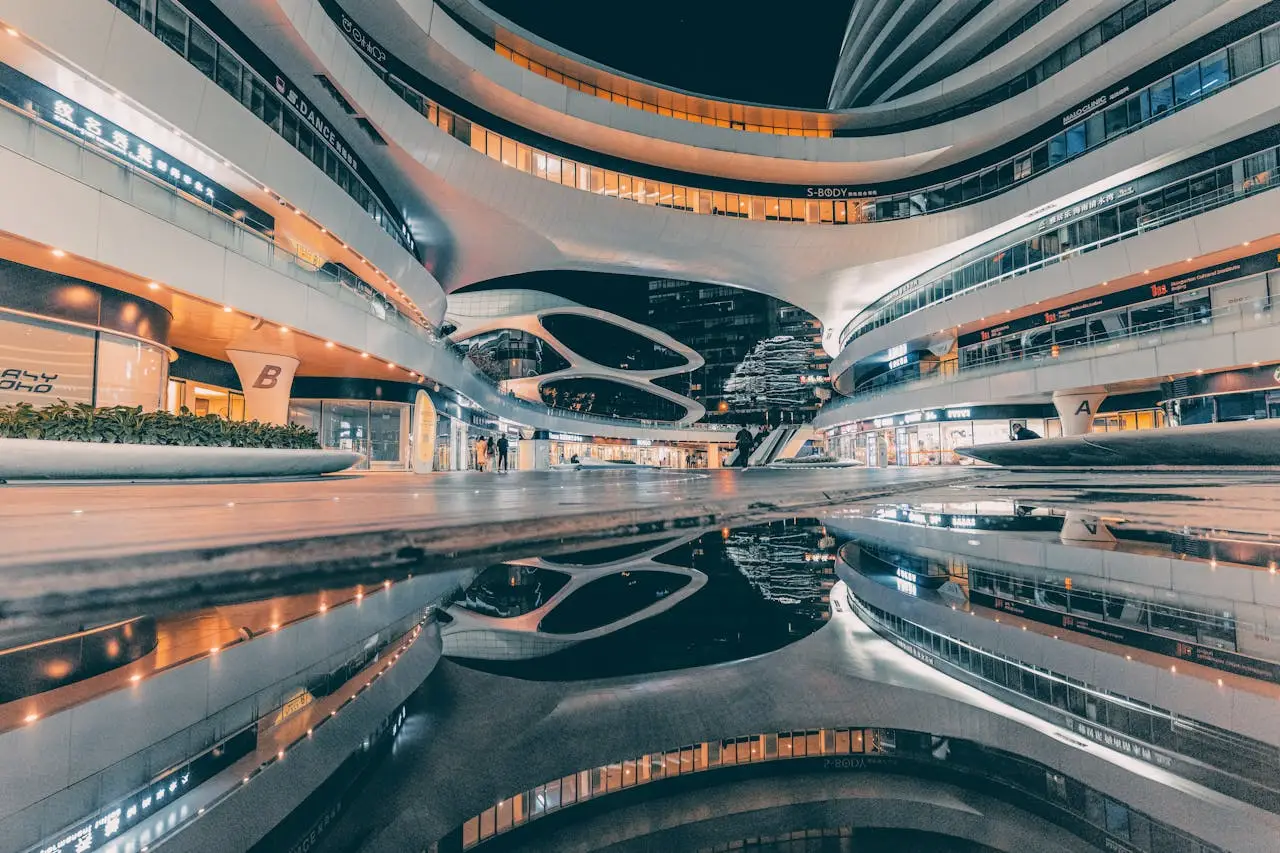 Night view of the futuristic Galaxy SOHO building in Beijing, China, showcasing modern architecture and reflections.